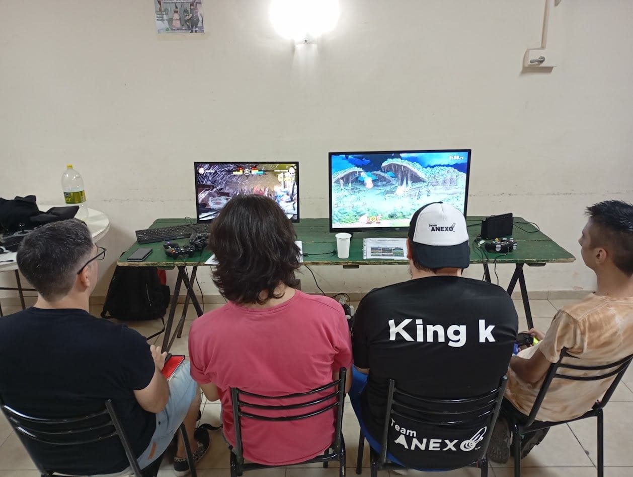 Jugadores compitiendo frente a dos monitores en un local