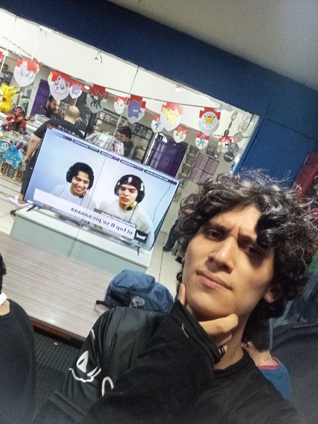 Jugador sonriendo en Planeta Comics frente a una partida